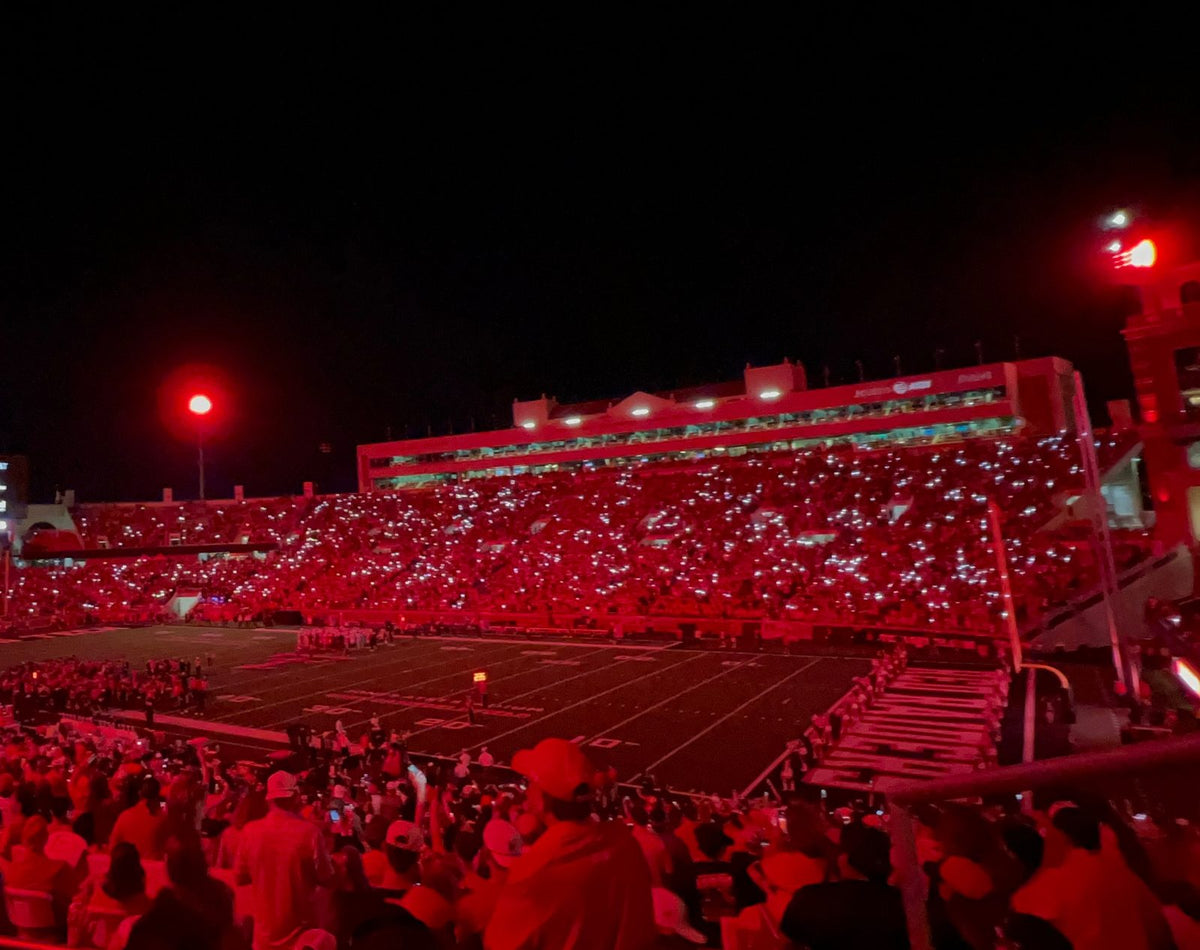 Night game in Lubbock: stands glowing red with phone lights